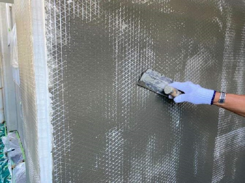 堺市にてモルタル外壁の劣化をピンネット工法で補修させて頂きました 工程4ネットを埋め込み下塗りをする
