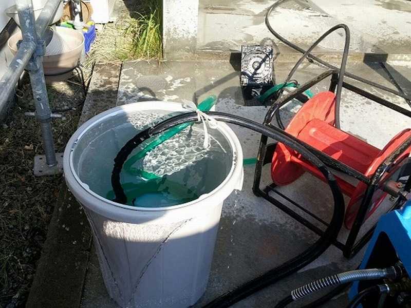 バケツに水を溜めて高圧洗浄を実施