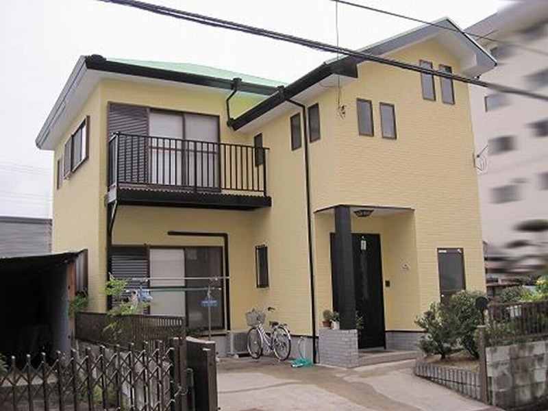 クリーム系の外壁と淡いグリーンの屋根の上品なデザイン