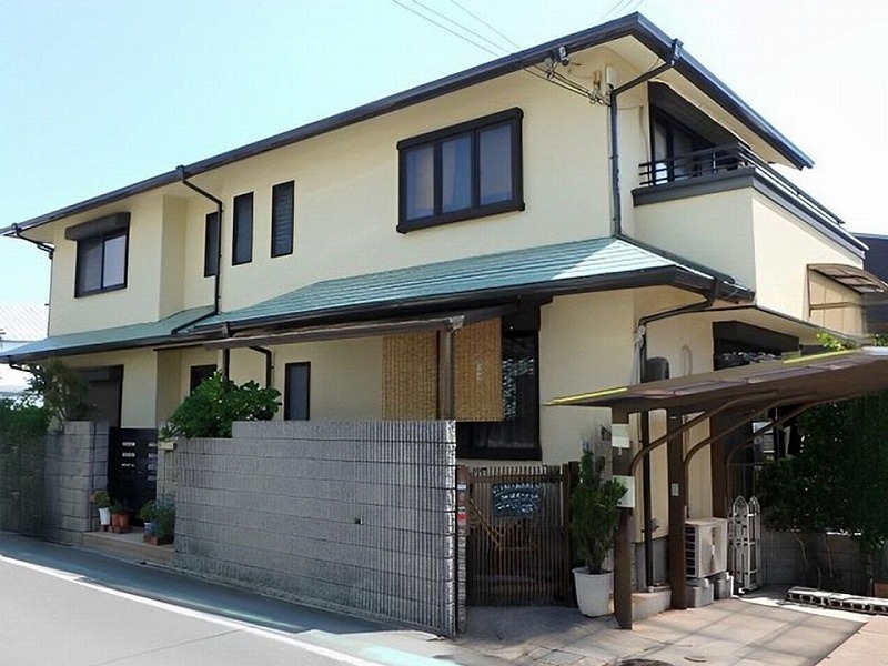 クリーム系の外壁と深みのあるグリーンの屋根がマッチした洗練されたデザイン