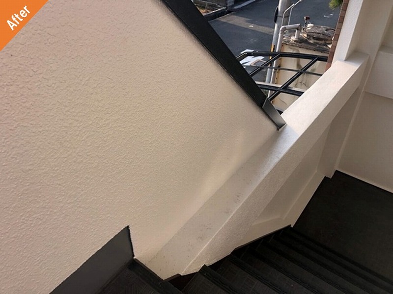 塗装工事後のマンション共用部のひび割れ補修された階段外壁